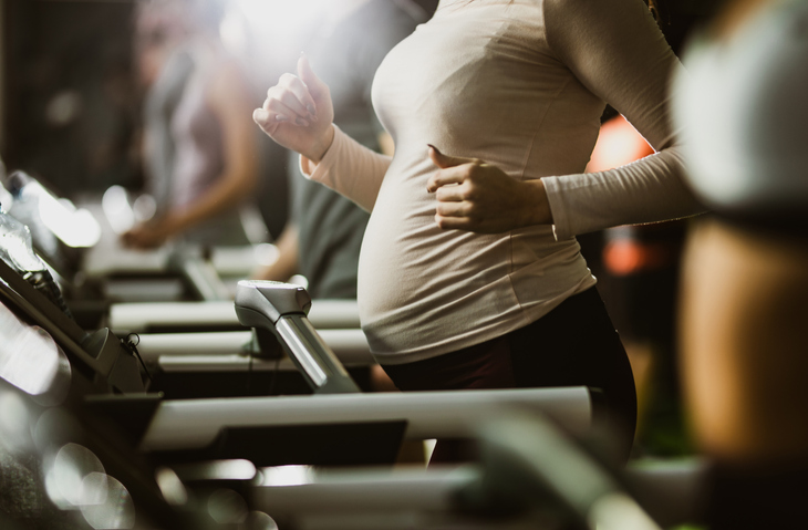 Zwangere dame sport op de cardio toestellen